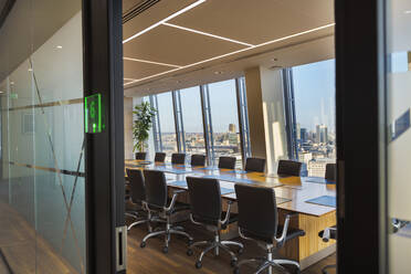 Moderner städtischer Konferenzraum mit langem Tisch und Stühlen - CAIF27747