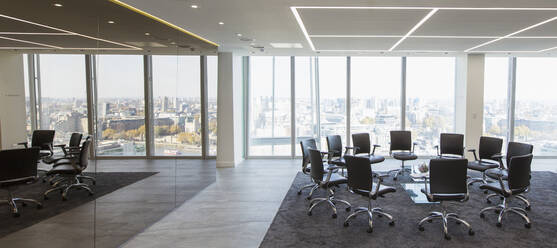 Chairs in a circle in modern highrise conference room - CAIF27754