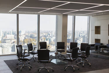 Chairs in circle in modern urban highrise office - CAIF27773