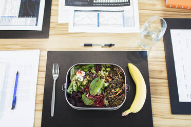 Healthy salad and banana lunch on conference table - CAIF27782