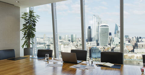 Laptop on conference room table in highrise office - CAIF27784