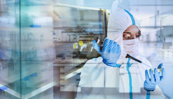 Female scientist in clean suit researching coronavirus in laboratory - CAIF27911
