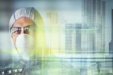 Porträt eines Wissenschaftlers mit Grippemaske am Stadtfenster - CAIF27923