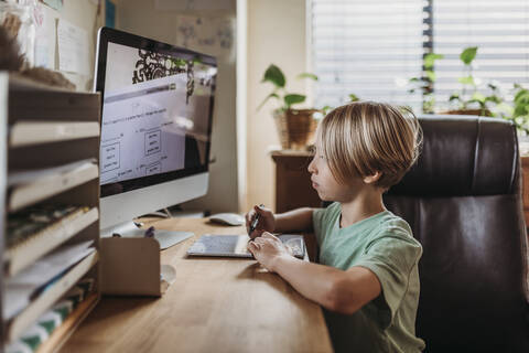 Side view of school aged boy learning from teacher conducting class stock photo