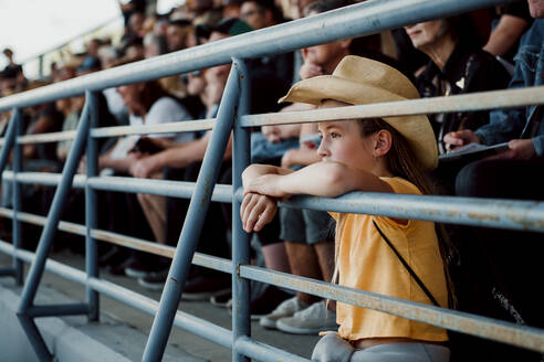 Kleines Mädchen mit Cowboyhut, das das Rodeo beobachtet - CAVF84244
