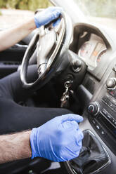Hände eines Mannes mit Handschuhen beim Autofahren - LJF01545