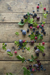 Frische Beeren, Pflaumen und Kirschen auf Holzoberfläche - ASF06624