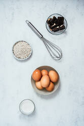 Some ingredients: eggs, chocolate, milk, oats and a beater on a beat - CAVF84247