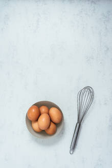 Einige Eier und ein Schneebesen auf einem Kochfeld - CAVF84250