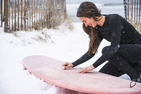 Frau beim Surfen im Winterschnee - CAVF84302