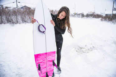 Frau beim Surfen im Winterschnee - CAVF84305