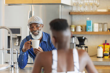 Vater und Tochter unterhalten sich in der Küche und trinken Kaffee - HOXF06376