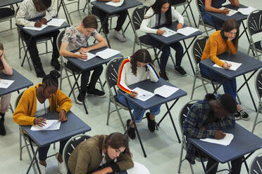 Fokussierte Oberstufenschüler, die an den Tischen im Klassenzimmer eine Prüfung ablegen - CAIF27969