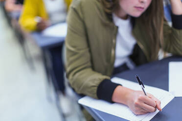 Highschool-Schülerin, die am Schreibtisch eine Prüfung ablegt - CAIF28013