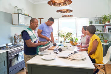 Reife Ehefrauen beobachten Ehemänner beim Kochen in der Küche - CAIF28028