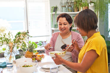 Freundinnen essen Salat in der Küche - CAIF28052