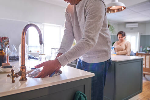 Mann beim Abwaschen an der Spüle - CAIF28081