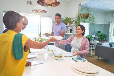 Mature couple friends preparing lunch in sunny kitchen - CAIF28097