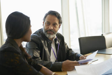 Business people discussing paperwork in conference room meeting - CAIF28116