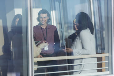 Business people talking in sunny window - CAIF28130