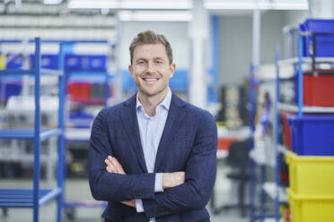 Confident male supervisor standing arms crossed in factory - RORF02174