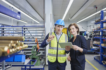 Supervisor and female manager discussing over digital tablet in factory - RORF02194