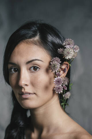 Schöne junge Frau mit Blumen im Haar, lizenzfreies Stockfoto