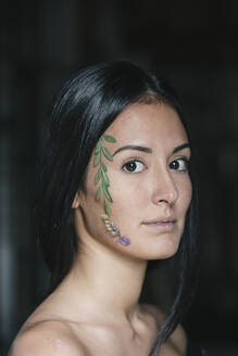 Beautiful young woman with leaves stuck on face - ALBF01238