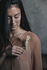 Beautiful young woman inserting flowers in pocket - ALBF01243