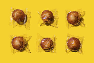 Studio shot of six plastic wrapped muffins - GEMF03810