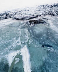 Luftaufnahme des Gletschers Solheimajokull mit schwarz-weißen Mustern, die durch im Eis eingeschlossene Vulkanasche entstanden sind, und seiner zugefrorenen Gletscherlagune, Südisland. - AAEF08775