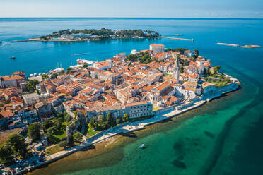 Luftaufnahme von Häusern umgeben von türkisfarbenem Wasser an einem sonnigen Tag in Porec, Kroatien - AAEF08822