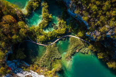 Luftaufnahme eines von türkisfarbenem Wasser umgebenen Holzstegs in Lower Lakes, Korana, Kroatien - AAEF08825