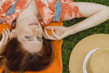 Schöne junge Frau entspannt sich auf Gras im Hinterhof - AFVF06582