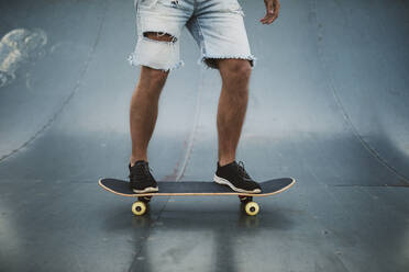 Junger Mann fährt Skateboard auf einer Sportrampe im Park - RAEF02386