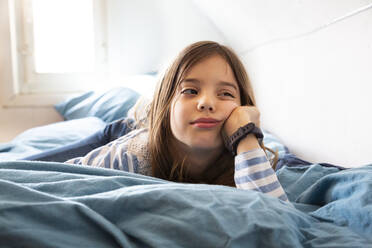 Portrait of bored little girl lying on bed - LVF08925