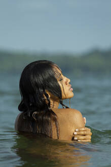 Topless young woman swimming in sea against sky - EAF00018