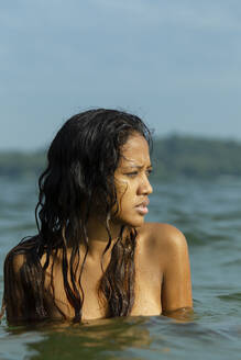 Topless thoughtful woman swimming in sea against sky - EAF00019