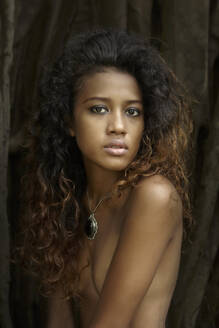 Topless young woman with curly hair sitting outdoors - EAF00021