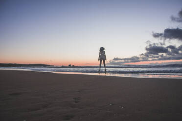 Silhouette young woman standing at beach against sky during sunset - FVSF00400