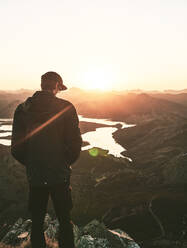 Männlicher Tourist bei Sonnenaufgang auf einem Berg stehend, Leon, Spanien - FVSF00414