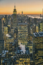 Blick auf die Skyline von Manhattan mit beleuchteten Wolkenkratzern bei Sonnenuntergang, New York City - ISF24194