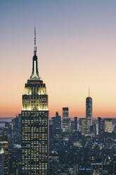 Blick auf die Skyline von Manhattan mit beleuchtetem Empire State Building bei Sonnenuntergang, New York City - ISF24195