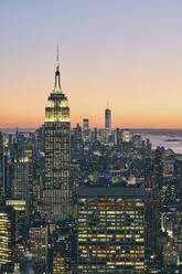 Blick auf die Skyline von Manhattan mit beleuchtetem Empire State Building bei Sonnenuntergang, New York City - ISF24196