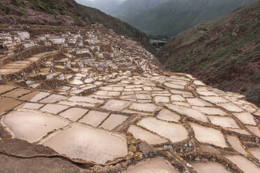 Berglandschaft mit dem terrassenförmigen Salzbergwerk Moray Maras im Vordergrund in der Nähe von Cusco, Peru. - ISF24204