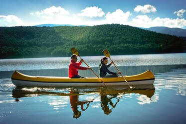Couple canoeing on Gusana lake, an artificial lake in the territory of Gavoi, Sardinia, Italy. - ISF24221