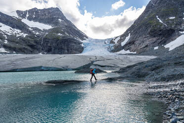 Side View Of Person Hiking At Glacier Lake Against Mountains - EYF05027