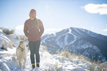 A woman and her lab on a walk on a beautiful winter morning. - CAVF84490