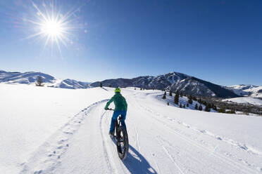 Eine Frau fährt mit ihrem Fatbike an einem schönen Wintertag im Sun Valley. - CAVF84491
