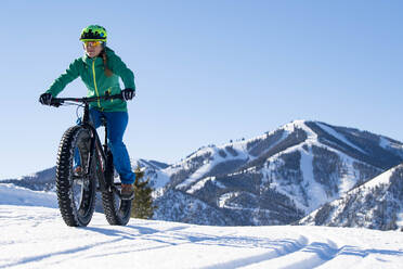 Eine Frau fährt mit ihrem Fatbike an einem schönen Wintertag im Sun Valley. - CAVF84492